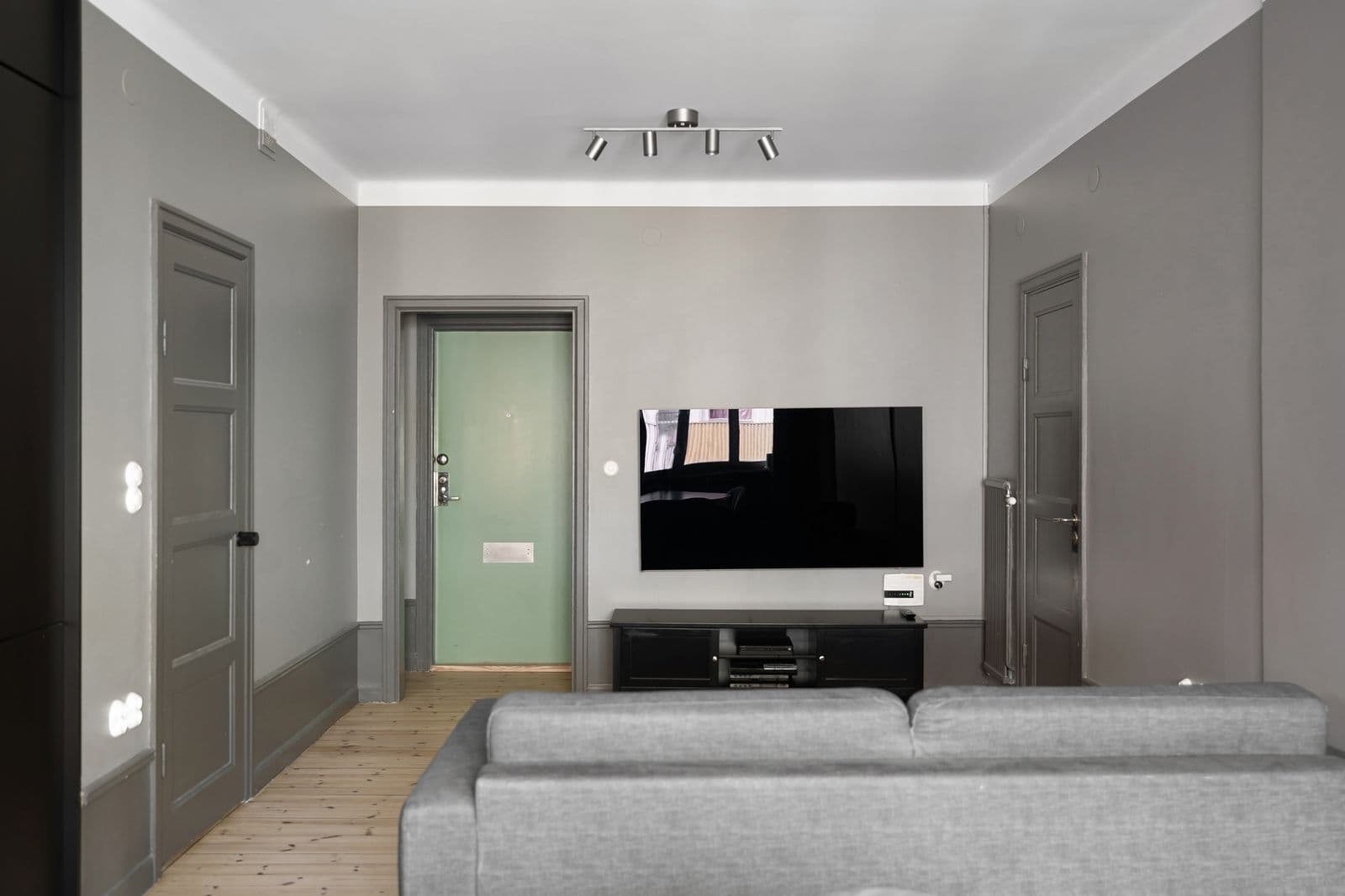 Television mounted flat on the wall of a minimalist modern living room